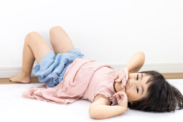 Obraz premium 絨毯に寝転がる笑顔の女の子（3歳、日本人、ショートヘア）