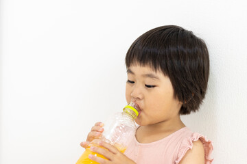 ペットボトルでジュースを飲む元気なの女の子（3歳、日本人、ショートヘア）