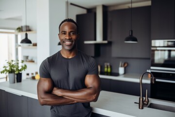 Naklejka premium Portrait of a smiling middle aged fit man in modern kitchen with fresh vegetables