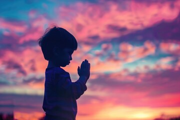 Fototapeta premium A young boy stands alone admiring the beautiful sunset