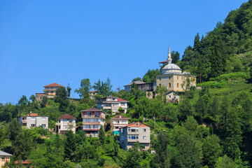 Cityscape on a summer day, modern buildings and houses against the blue sky 