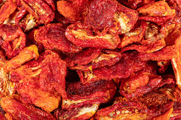 Sun dried tomatoes, dried red and yellow cherry tomatoes, close up, top view. Sun dried tomato background. Dried dehydrated tomato chips. Healthy eating concept.