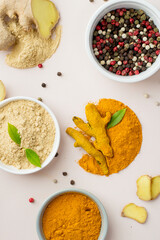 Assortment of spices on a light background, top view. Turmeric, ginger, peppercorns. A variety of spices, whole and ground.