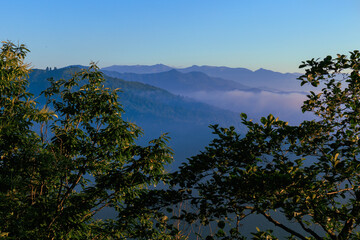 Landscape horizon line in the mountains, orange sunset and blue mountains.