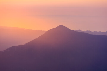 Landscape horizon line in the mountains, orange sunset and blue mountains.