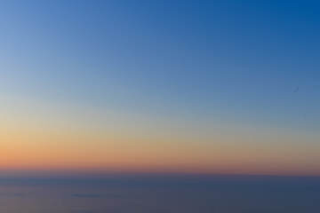 Landscape horizon line in the mountains, pink orange sunset and blue mountains.
