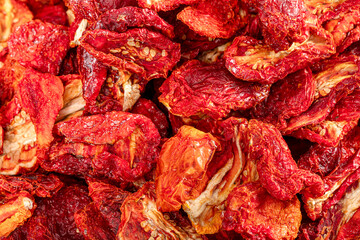 Sun dried tomatoes, dried red and yellow cherry tomatoes, close up, top view. Sun dried tomato background. Dried dehydrated tomato chips. Healthy eating concept.