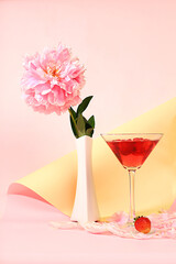 Modern still life with pink martini, alcoholic cocktail, strawberries and peony flowers on elegant modern background, minimal concept for bar and holiday party, cafe, advertising banner, 