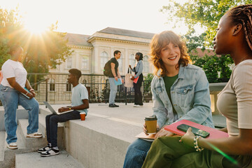 Diverse students sitting and standing on stairs at university campus.