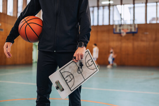 Coach with basketball and strategy board - Powered by Adobe