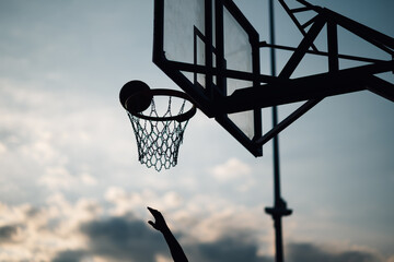 Silhouette of basketball shot at dusk