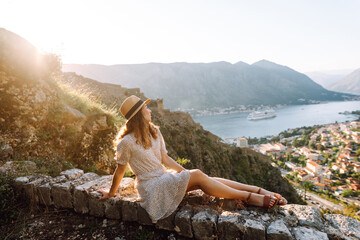 Young woman tourist on top with a view of the mountain bay admiring view of colorful the view of the city. Europe travel. Lifestyle, vacation, rest, active life.