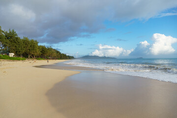 A serene beach setting with a backdrop of blue skies and fluffy clouds