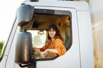 Young woman driving truck. Trucker female worker, transport industry occupation.