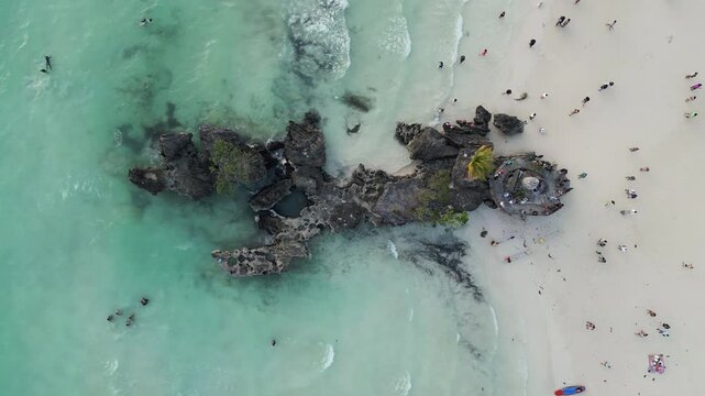 Captivating drone footage of the Willy's Rock, a popular stone formation situated next to the western coast of Boracay island, Philippines. Aerial top view.