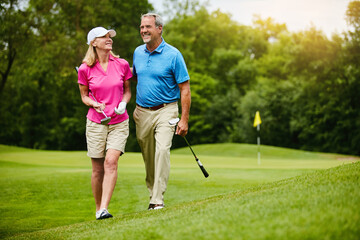 Mature, couple and walk on golf course, outside and healthy fitness activity with golfers together with club. Relaxing, weekend break and happy with smile for sport, nature exercise and people