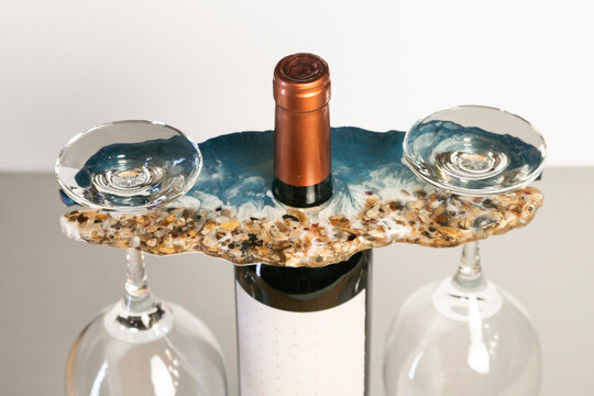 Soportes  elegantes y funcionales, personalizados  para sostener botellas y copas,  diseñados para elevar cualquier experiencia de bebida. Fabricados con resina simulando arena y mar.