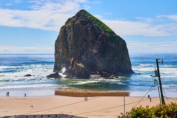 Haystack Rock with Ocean Waves and Beach Walkers from Elevated View
