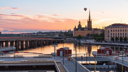 Obraz premium The newly opened Vattentorget, with the canal locks, connection Slussen to Gamla Stan (Old town) Stockholm. Summer evening, orange lights, historical buildings, hot air balloon. 