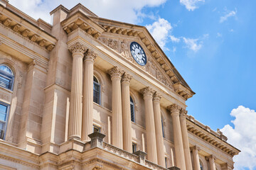 Obraz premium Neoclassical Courthouse Facade with Clock and Columns Low Angle View