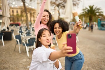 Obraz premium Multiethnic Friends having fun with ice cream and taking selfies