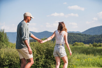 Cheerful couple on a summer lake vacation, going on a canoe ride. Romantic weekend getaway concept.