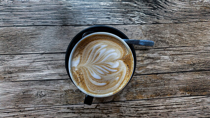 Cup of decaf coffee Latte with foam, on a old wooden table.