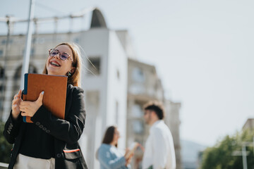 Obraz premium Happy businesswoman holding a tablet with colleagues in the background. Corporate outdoor meeting with positive atmosphere.