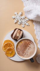 A cup of warm cocoa with macaroon and cozy winter decor flat lay. Warm drink top view