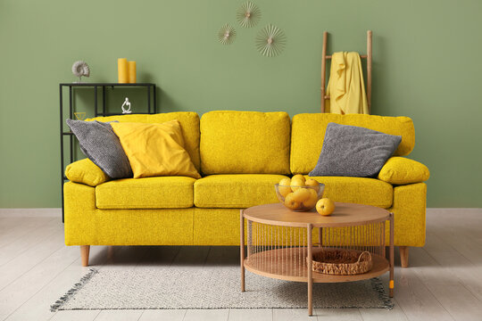 Interior of modern living room with black sofa, oranges on coffee table and pillow