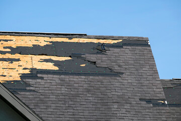 Consequences of natural disaster. Damaged house roof with missing shingles after hurricane Ian in Florida © bilanol
