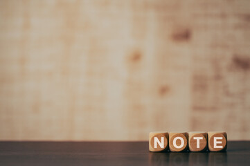 There is wood cube with the word NOTE. It is as an eye-catching image.