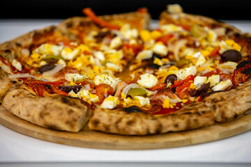 traditional Portuguese pizza with boiled eggs, black olives, ham