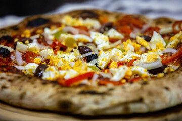 traditional Portuguese pizza with boiled eggs, black olives, ham