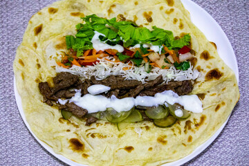 Traditional Shawarma sandwich fresh roll of, Grilled Meat and salad tortilla wrap with white sauce...