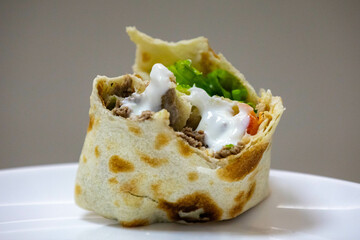 Traditional Shawarma sandwich fresh roll of, Grilled Meat and salad tortilla wrap with white sauce...