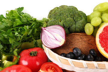 Wicker bowl with different fresh fruits and vegetables on white background, closeup