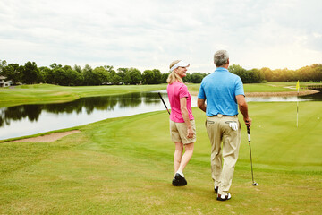 Outdoor, mature and couple walking on golf course for conversation, game advice and end of hole...