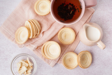 Homemade tartlets and cup of hot tea on light background