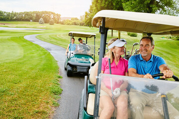 People, golf cart and outside field or driving, happy and relax in transport for country club hobby on weekend break. Fitness, couple and smile on sport course for game, golfers and together on path © Reese Coop/peopleimages.com