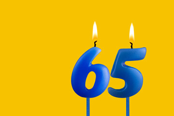 Blue candle number 65 - Birthday on yellow background