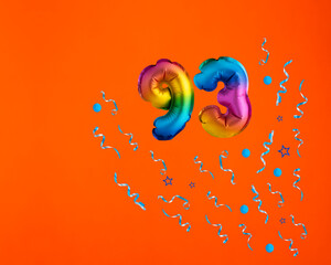Multicolor balloon number 93 - Confetti explosion on orange background. Birthday card