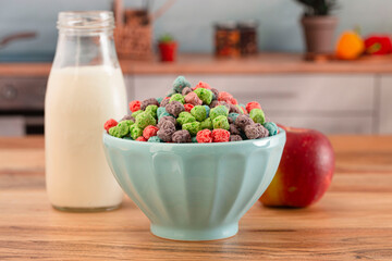 A Bowl Full of Red Purple Green and Blue Berry Flavored Kids Cereal on a Wooden Kitchen Counter