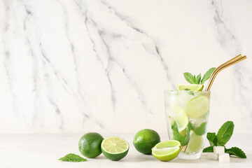 Glass of fresh Mojito cocktail with limes, mint and sugar on white background