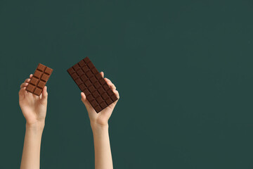 Female hands with different sweet chocolate on green background