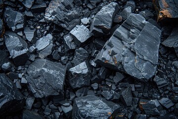 A detailed close-up of broken, dark rocks scattered across the ground in a mining area, offering a glimpse into the textures, shapes, and compositions typically encountered in mining.