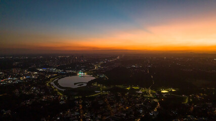 Curitiba in Paraná, Brazil. Aerial View. Wonderful sunset with views of buildings and Tanguá Park. Lake with reflection..