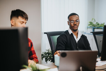 Focused business professionals in a modern office environment. Diverse team of young colleagues analyze documents, discussing strategies and success, representing teamwork and communication.
