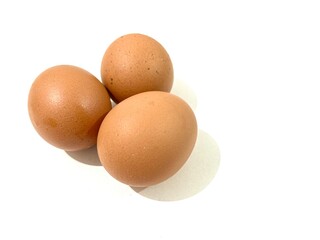Three fresh and raw chicken brown eggs isolated on white background