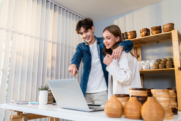 Attractive man and woman sell vase product online live stream at home. 